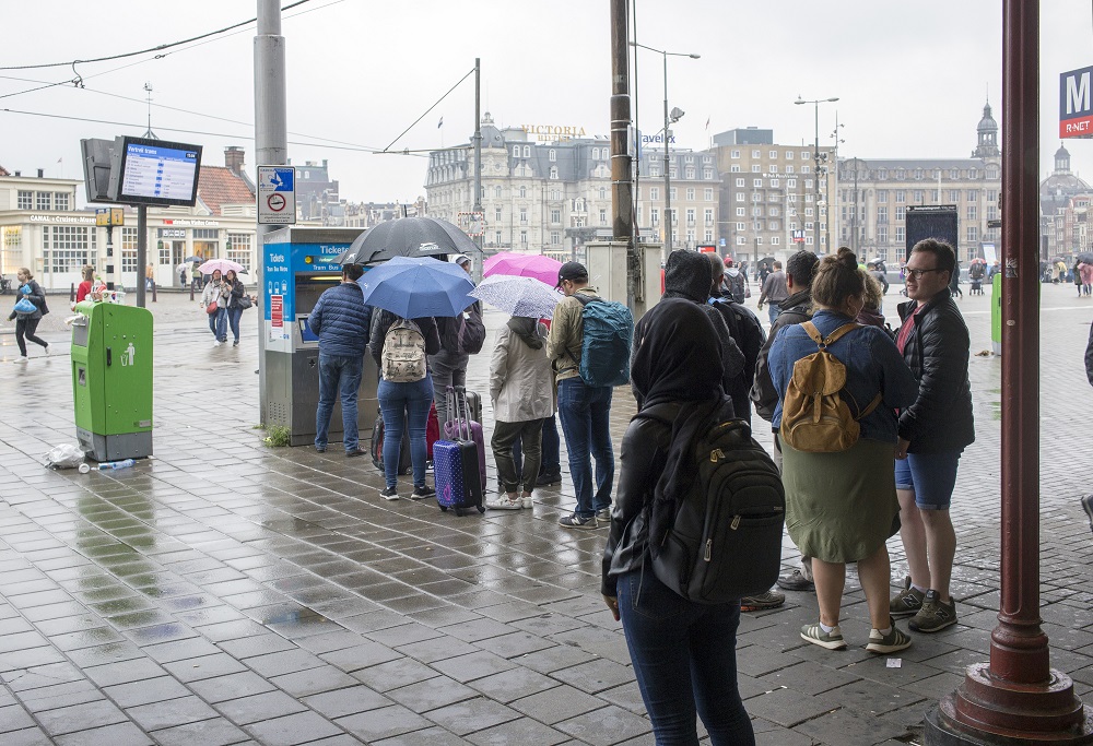 Toeristen in de rij voor GVB-kaartautomaat
