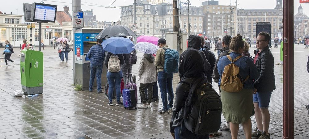 Toeristen in de rij voor GVB-kaartautomaat